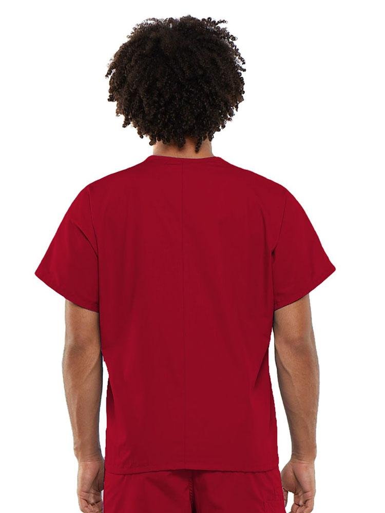 A young male Clinical Laboratory Technician wearing a Cherokee Workwear Originals Unisex Single Pocket V-neck Scrub Top in Red size Large featuring a center back length of 27.5".