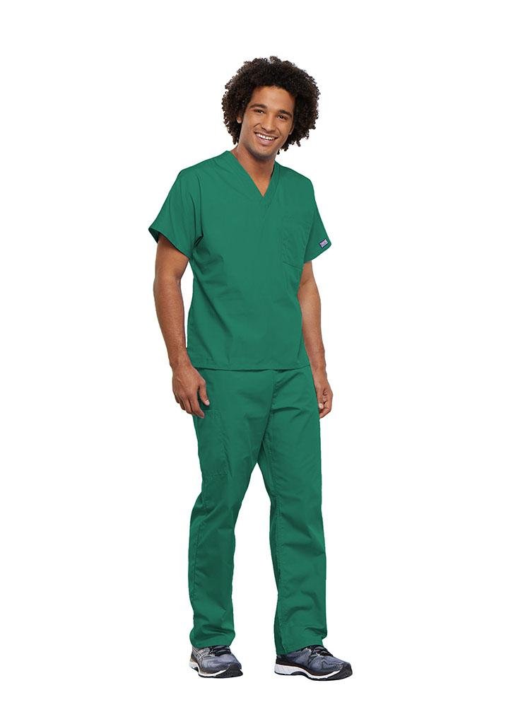 A male Surgical Technician wearing a Cherokee Workwear Originals unisex Single Pocket V-Neck Scrub Top in Surgical Green size 5XL featuring 1 spacious chest pocket.