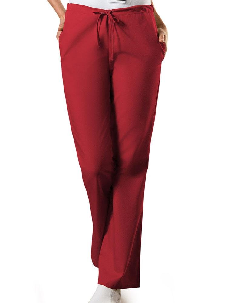 A young female Medical Assistant wearing a Cherokee Workwear Originals Women's Drawstring Flare Leg Scrub Pant in Red size XS Petite featuring an adjustable drawstring waist.