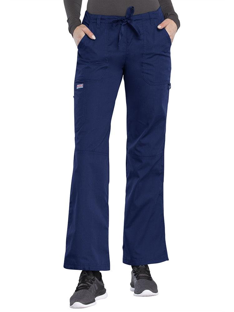 A young female Respiratory Therapist wearing a Cherokee Workwear Originals Women's Low-Rise Drawstring Scrub Pant in Navy size Small Tall featuring an adjustable drawstring waist.
