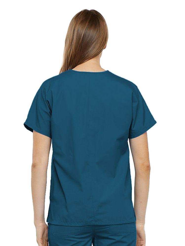 A young female Home Health Aide wearing a Cherokee Workwear Originals Women's V-neck Scrub Top in Caribbean size medium featuring a center back length of 26.5".