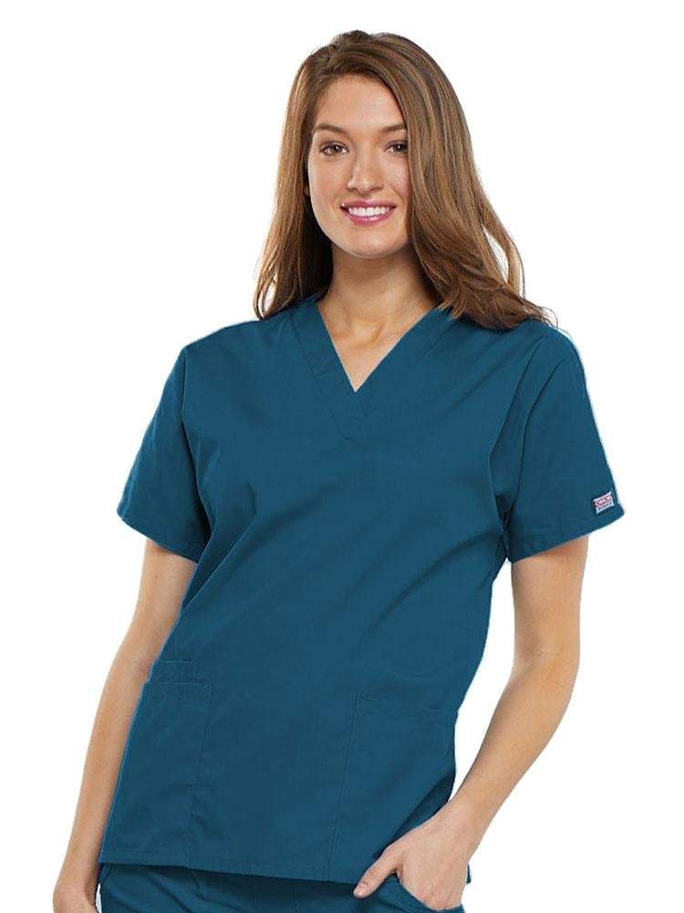A young female LPN wearing a Cherokee Workwear Originals Women's V-neck Scrub Top in Caribbean size 2XL featuring short sleeves.