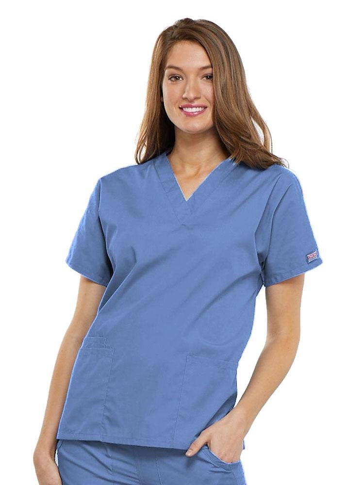 A young female Physical Therapist wearing a Cherokee Workwear Originals Women's V-neck Scrub Top in Ceil size 2XL featuring short sleeves.