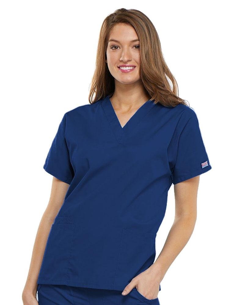 A young female Family Practitioner wearing a Cherokee Workwear Originals Women's V-neck Scrub Top in Galaxy Blue size 2XL featuring short sleeves.
