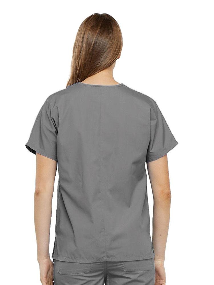 A young female Physical Therapy Aide wearing a Cherokee Workwear Originals Women's V-neck Scrub Top in Grey size medium featuring a center back length of 26.5".