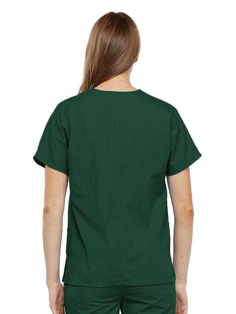 A young female Surgical Technologist wearing a Cherokee Workwear Originals Women's V-neck Scrub Top in Hunter Green size 2XL featuring a center back length of 26.5".