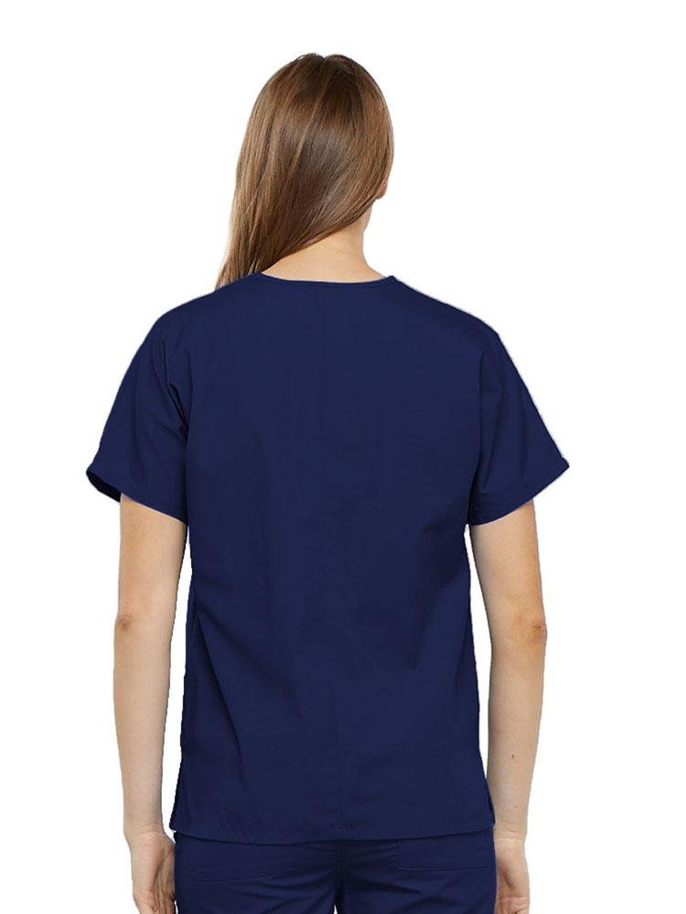 A young female Home Health Aide wearing a Cherokee Workwear Originals Women's V-neck Scrub Top in Navy size medium featuring a center back length of 26.5".