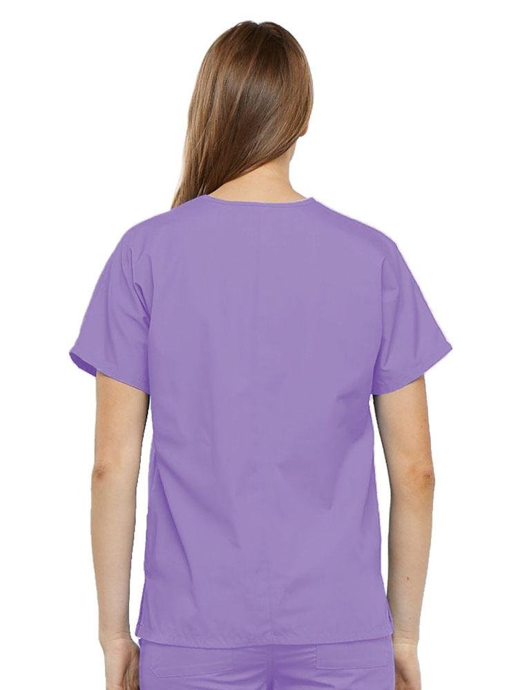 A young female LPN wearing a Cherokee Workwear Originals Women's V-neck Scrub Top in Orchid size medium featuring a center back length of 26.5".