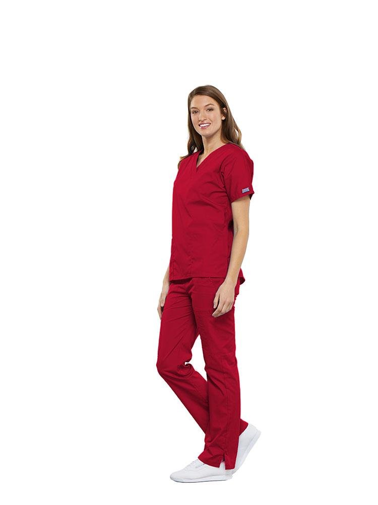 A female Clinical Laboratory Technologist wearing a Cherokee Workwear Originals women's Multi-Pocketed V-Neck Scrub Top in Red size Large featuring side seam vents for additional range of motion throughout the day.