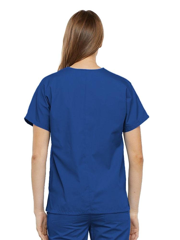 A young female LPN wearing a Cherokee Workwear Originals Women's V-neck Scrub Top in Royal size medium featuring a center back length of 26.5".