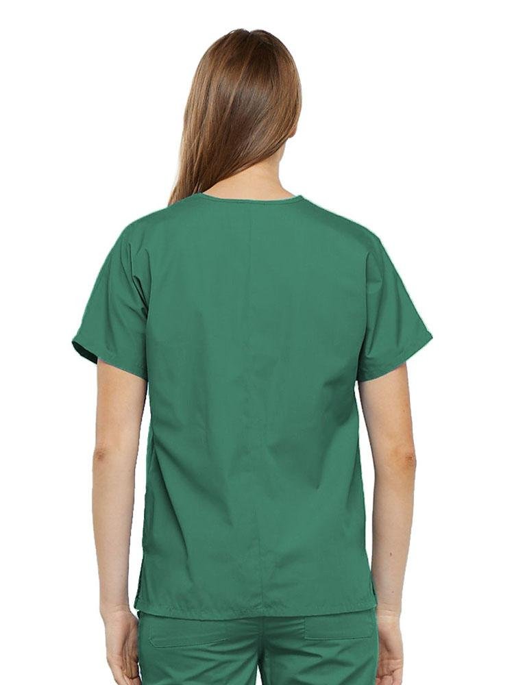 A young female Home Health Aide wearing a Cherokee Workwear Originals Women's V-neck Scrub Top in Surgical Green size medium featuring a center back length of 26.5".