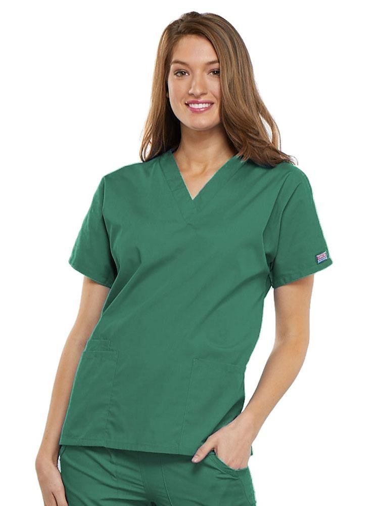 A young female LPN wearing a Cherokee Workwear Originals Women's V-neck Scrub Top in Surgical Green size 2XL featuring short sleeves.