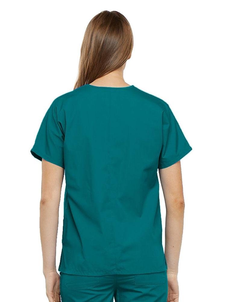 A young female LPN wearing a Cherokee Workwear Originals Women's V-neck Scrub Top in Teal size medium featuring a center back length of 26.5".