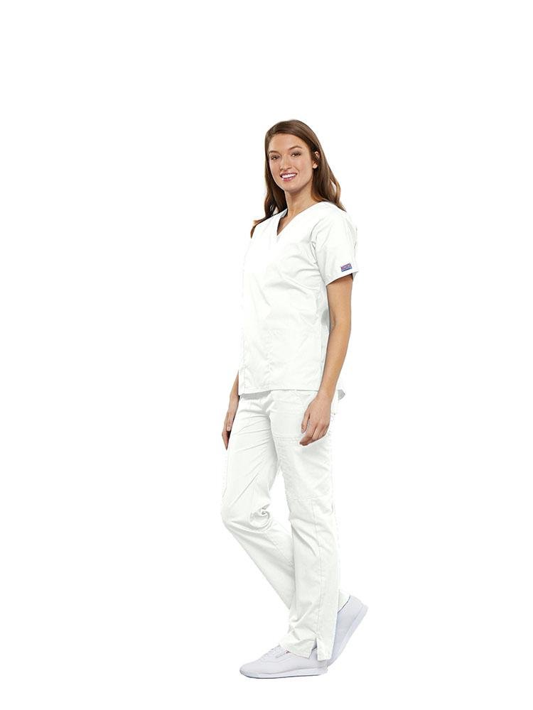 A female Clinical Laboratory Technologist wearing a Cherokee Workwear Originals women's Multi-Pocketed V-Neck Scrub Top in White size Large featuring side seam vents for additional range of motion throughout the day.