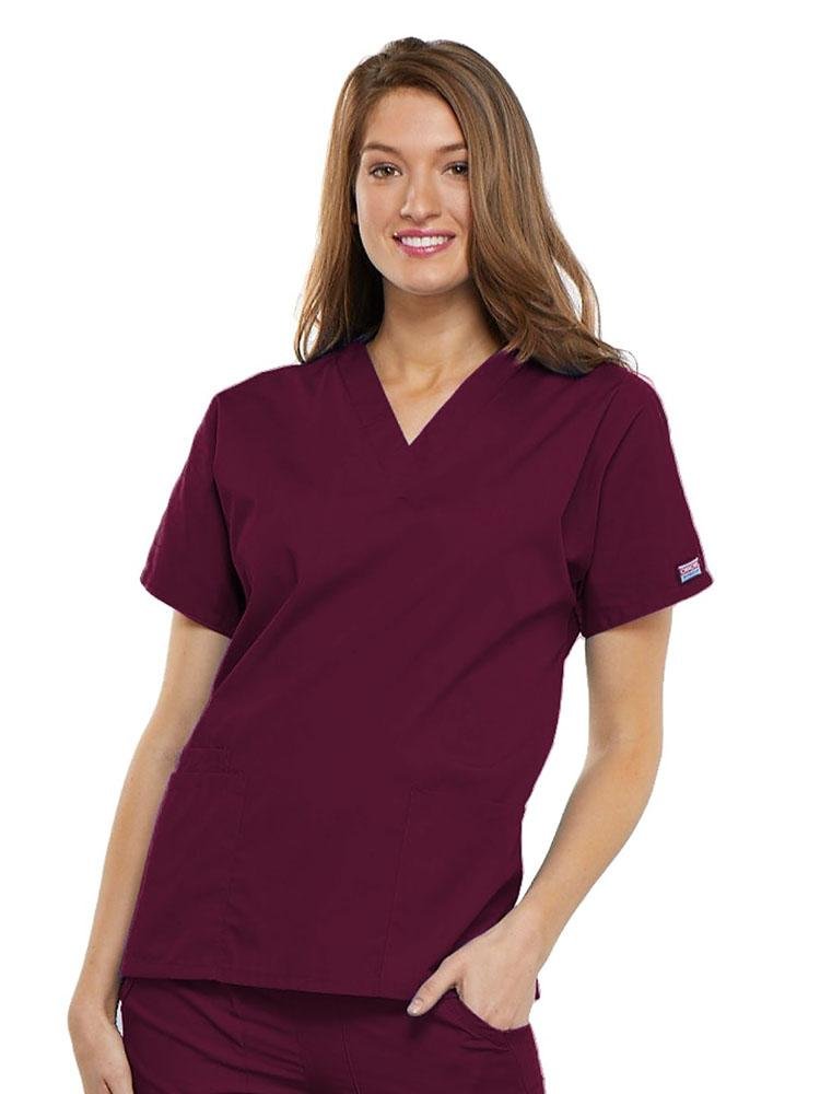 A young female EMT wearing a Cherokee Workwear Originals Women's V-neck Scrub Top in Wine size 3XL featuring short sleeves.