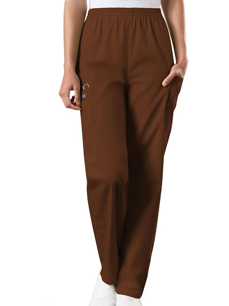 A young female Emergency Medical Technician wearing a Cherokee Workwear Originals Women's Natural Rise Tapered Pull-On Scrub Pant in Chocolate size Medium Petite featuring an elastic waist.