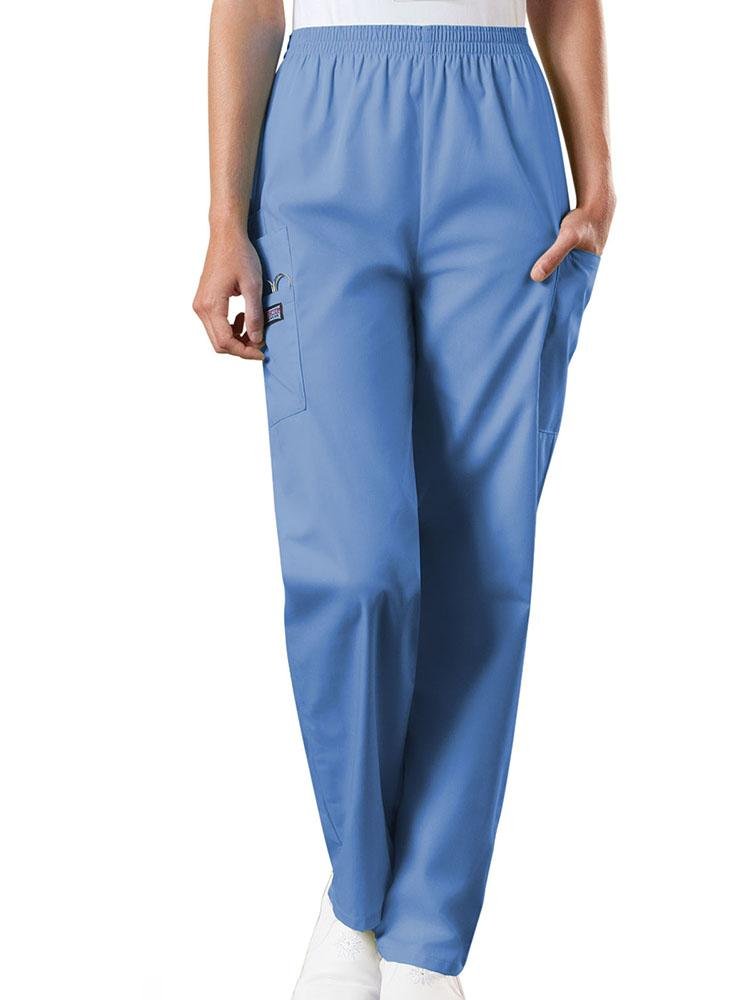A young female Radiologic Technologist wearing a pair of Women's Natural Rise Tapered Pull-On Scrub Pant from Cherokee Workwear Originals in Ceil size XL featuring a total of 4 pockets.
