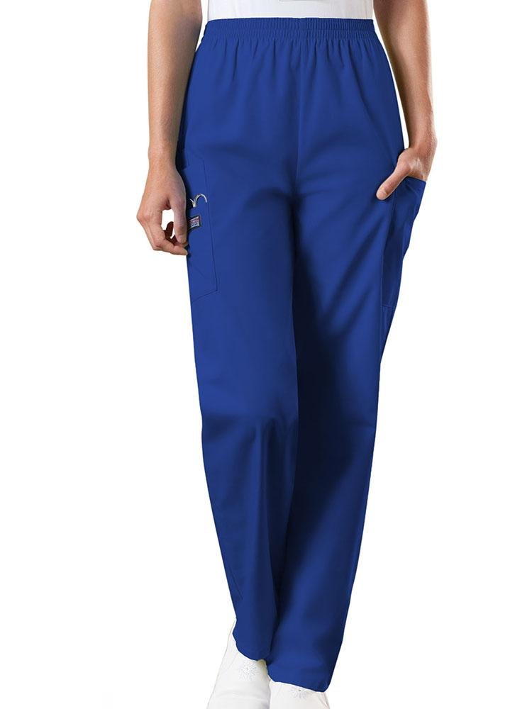 A young female Radiologic Technologist wearing a pair of Women's Natural Rise Tapered Pull-On Scrub Pant from Cherokee Workwear Originals in Galaxy Blue size XL featuring a total of 4 pockets.
