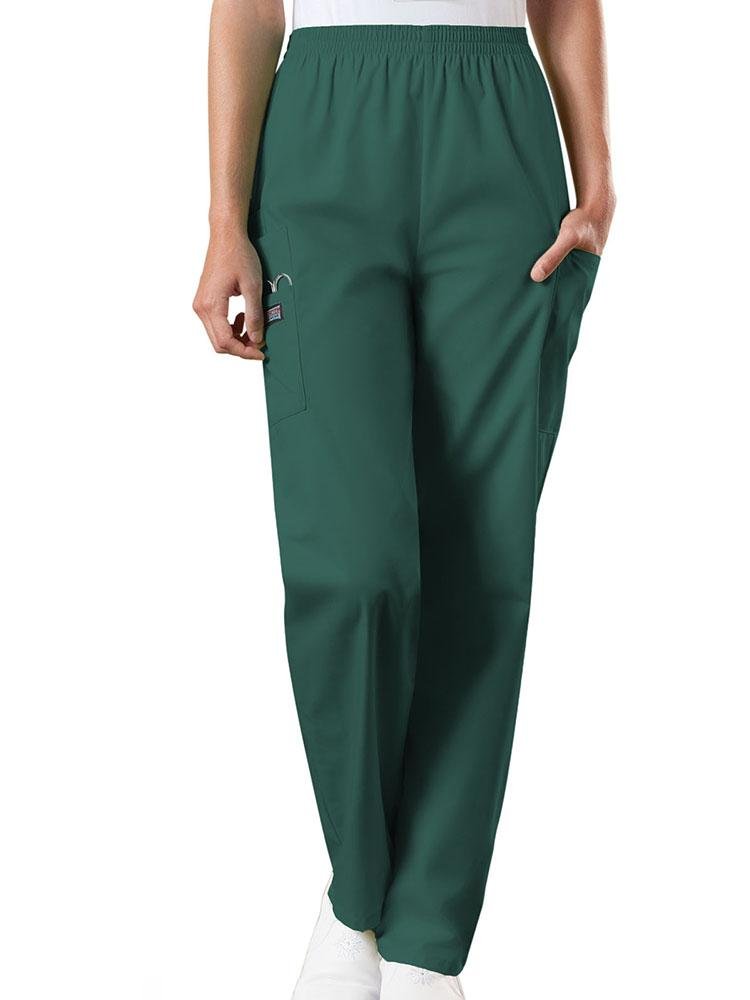 A young female Radiologic Technologist wearing a pair of Women's Natural Rise Tapered Pull-On Scrub Pant from Cherokee Workwear Originals in Hunter Green size XL featuring a total of 4 pockets.