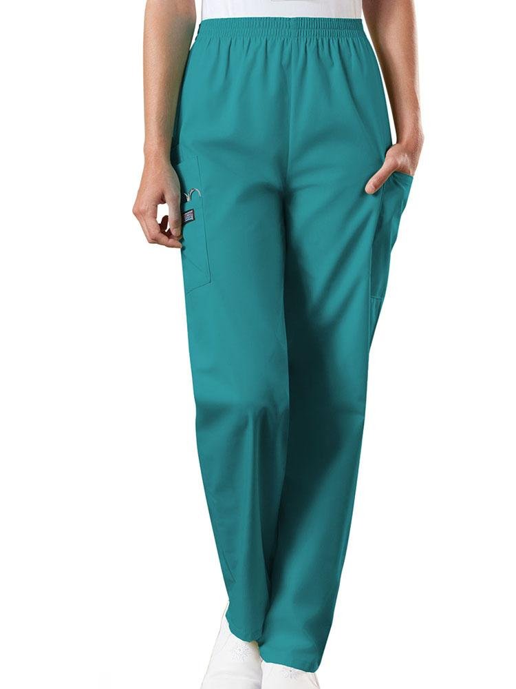 A young female Radiologic Technologist wearing a pair of Women's Natural Rise Tapered Pull-On Scrub Pant from Cherokee Workwear Originals in Teal size XL featuring a total of 4 pockets.