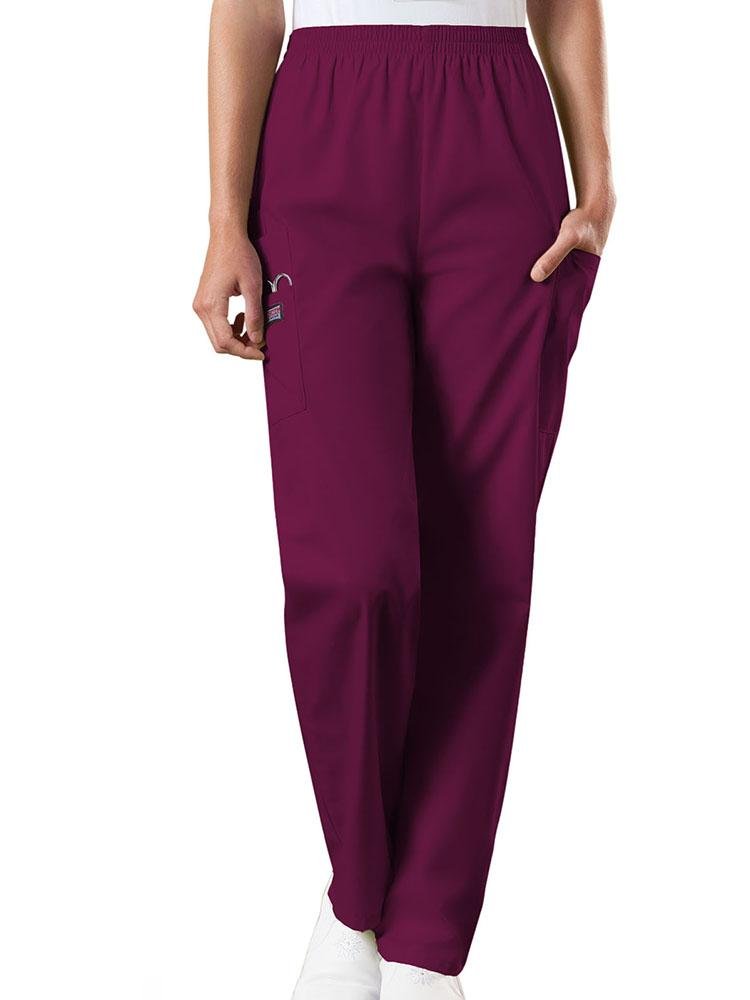 A young female Radiologic Technologist wearing a pair of Women's Natural Rise Tapered Pull-On Scrub Pant from Cherokee Workwear Originals in Wine size XL featuring a total of 4 pockets.