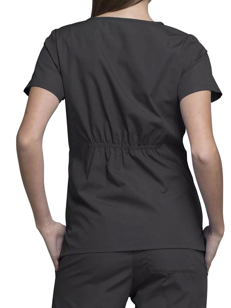 A young female Clinical Laboratory Technologist wearing a Cherokee Workwear Original's Women's Notch Crew Round Neck Scrub Top in Pewter size Medium featuring back elastic to provide a flattering all day fit.