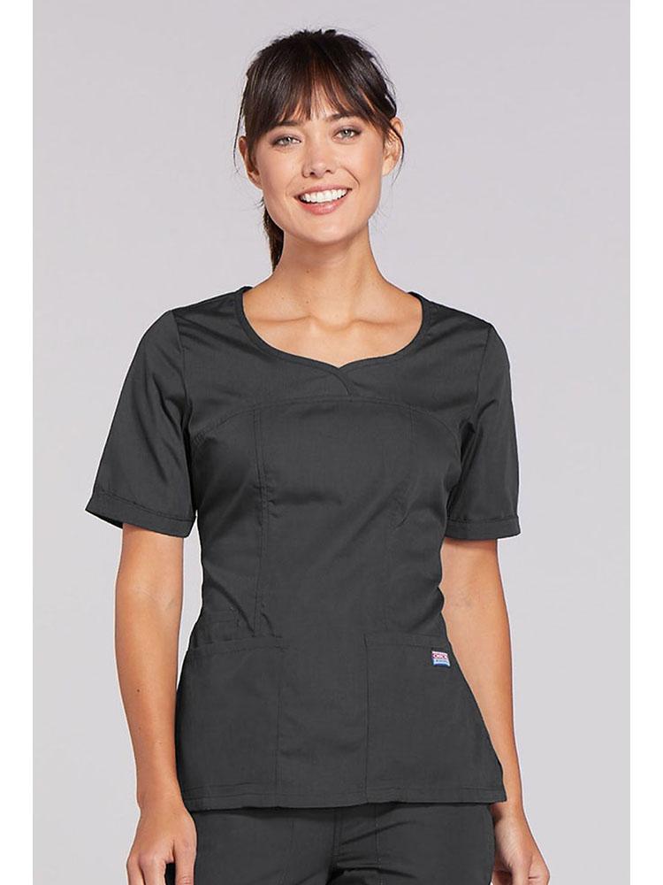 A young female Physical Therapist wearing a Cherokee Workwear Original's Women's Novelty Crossed V-neckline Scrub Top in Pewter size 2XL.