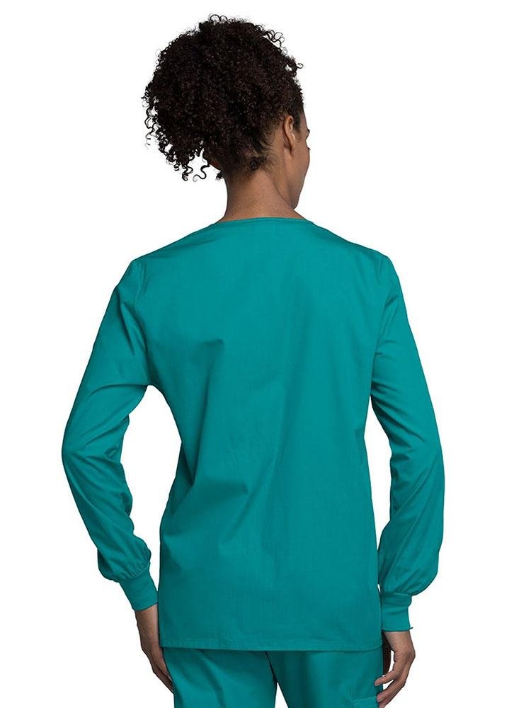 A view of the back of a Cherokee Workwear Originals Women's Snap Front Warm-Up Jacket in Teal size Medium with soil release fabric.