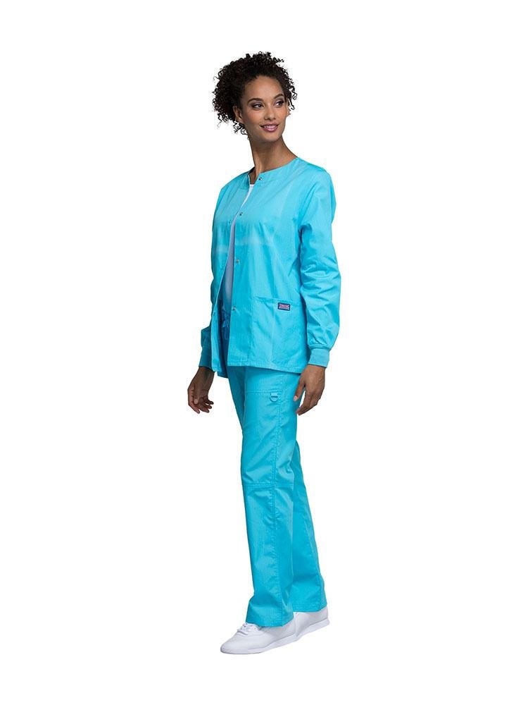 A female Dental Hygienist wearing a Cherokee Workwear Originals women's Snap Front Warm-Up Jacket in Turquoise size extra extra small featuring a unique polyester/cotton blend fabric.