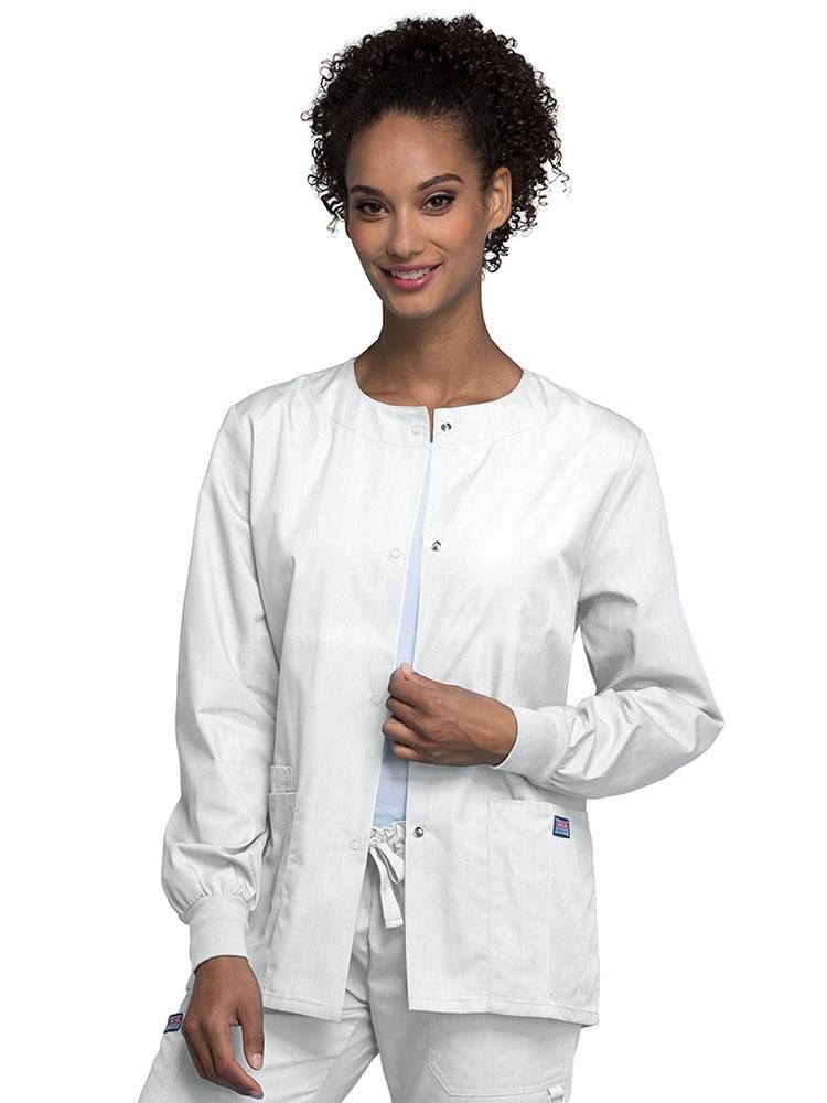 A young female LPN wearing a Cherokee Workwear Originals Women's Snap Front Warm-Up Jacket in White featuring A Traditional Classic fit & a round neck.