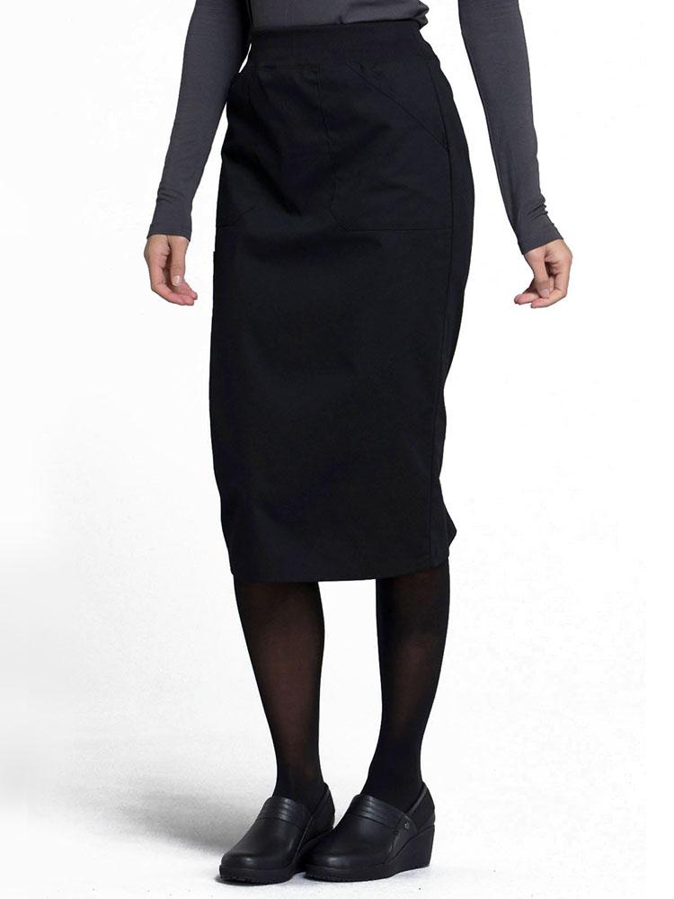 Side view of Caretaker wearing Cherokee Worwear Professionals women's 30" Knit Waistband Scrub Skirt  in black size medium