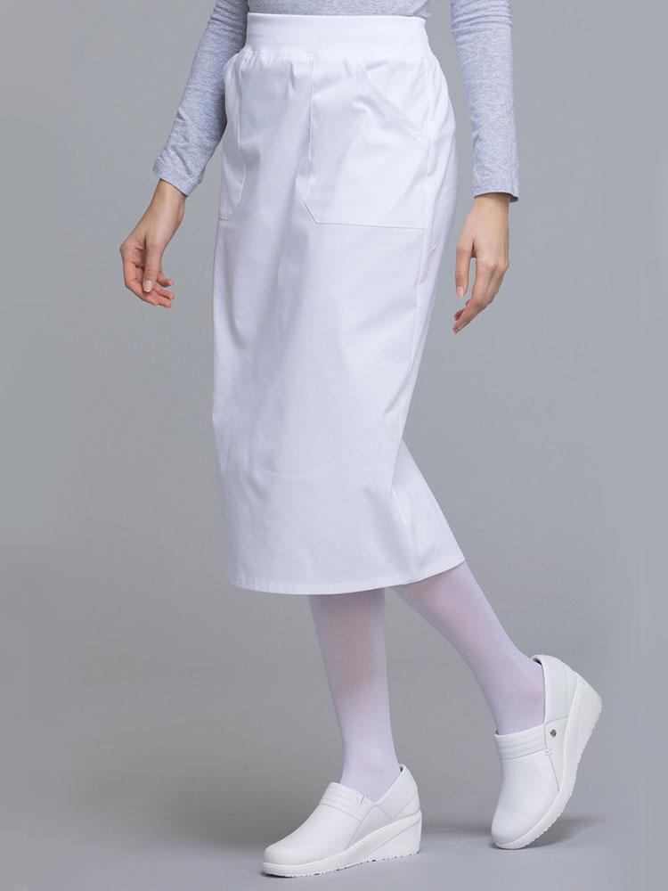 Side view of Esthetician wearing Cherokee Worwear Professionals women's 30" Knit Waistband Scrub Skirt  in white size 4X