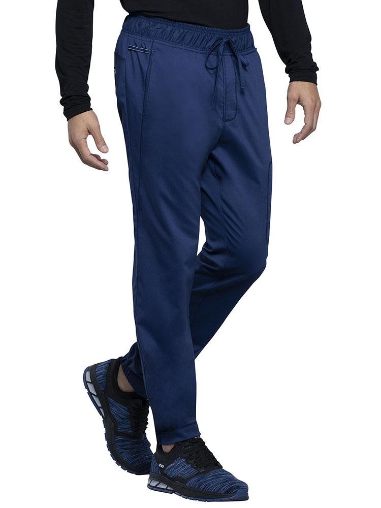 Physician wearing Cherokee Workwear Revolution men's Jogger Scrub Pant in navy size medium