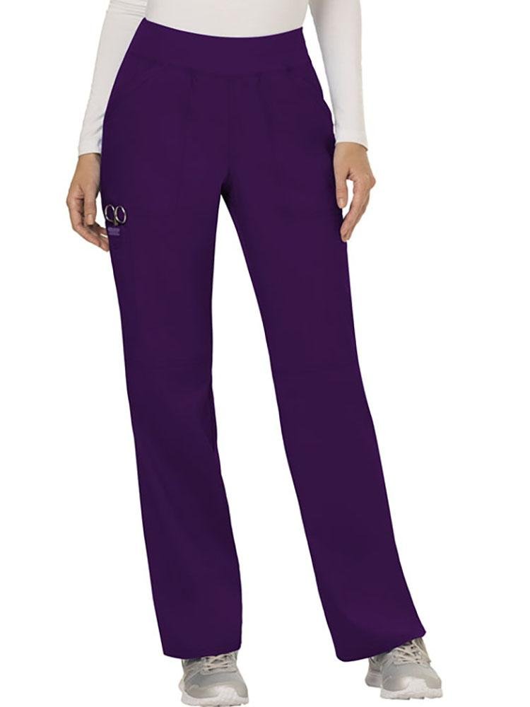 A young female Nurse wearing Cherokee Workwear Revolution women's Elastic Waistband Pull-On Scrub Pant in Eggplant size  small.