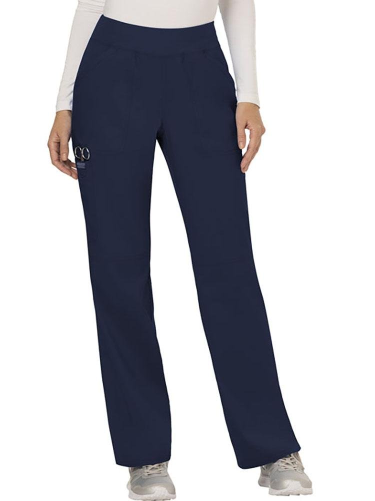 A young female CNA wearing Cherokee Workwear Revolution women's Elastic Waistband Pull-On Scrub Pant in Navy size extra extra small.