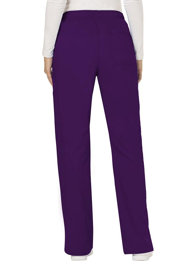 A female Diagnostic Medical Sonographer wearing a Cherokee Workwear Revolution Women's Mid Rise Moderate Flare Scrub Pant in Eggplant size Medium Tall featuring a back patch pocket for additional storage space.