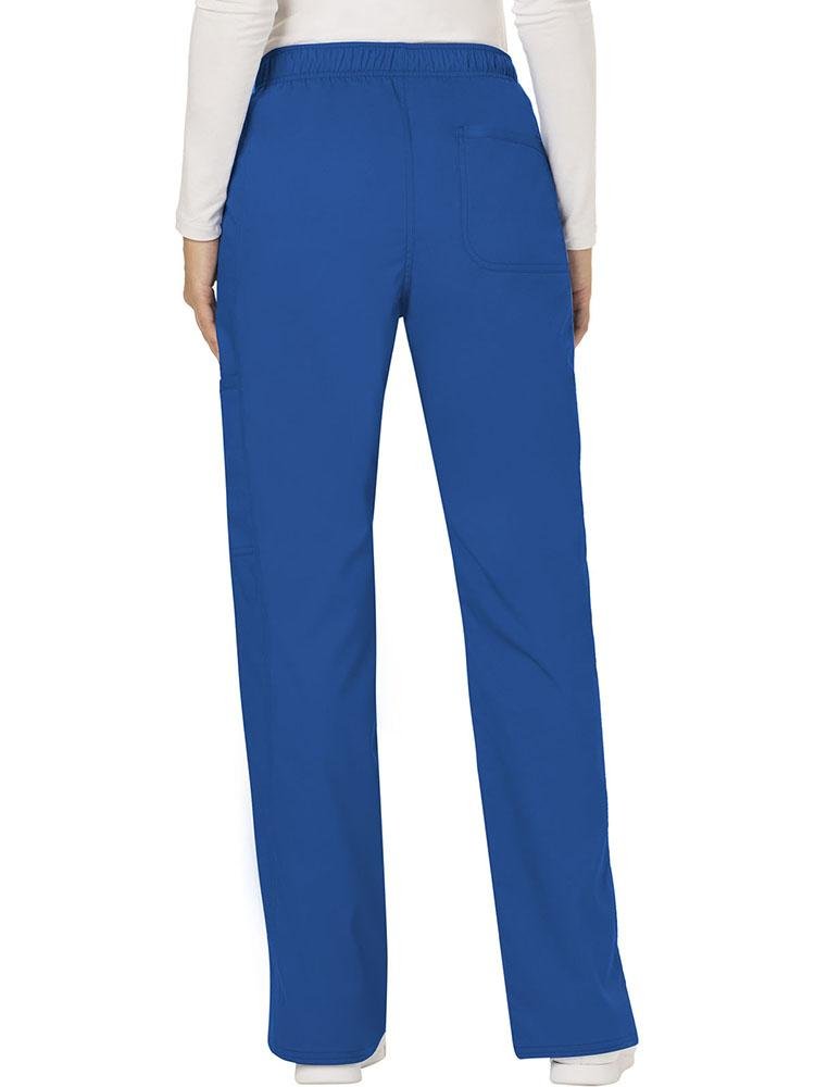 A female Nurse Practitioner wearing a Cherokee Workwear Revolution Women's Mid Rise Moderate Flare Scrub Pant in Royal Blue size Medium Tall featuring a back patch pocket for additional storage space.