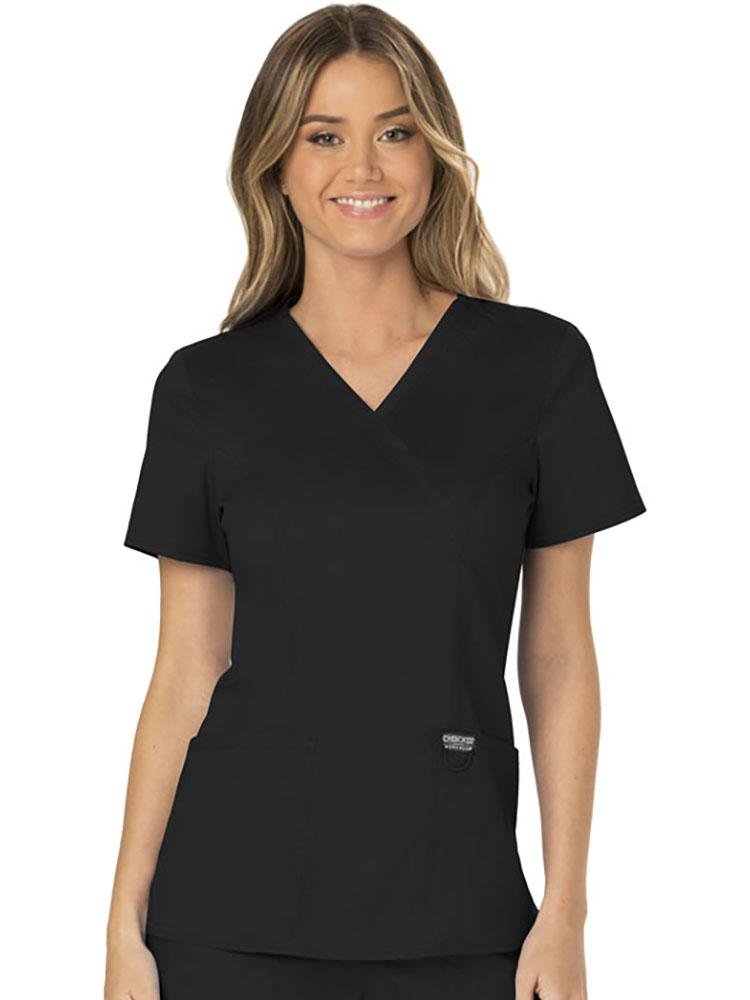 A female Dietician wearing a Cherokee Workwear Revolution Women's Mock Wrap Scrub Top in black size extra large featuring a modern classic fit with short sleeves.