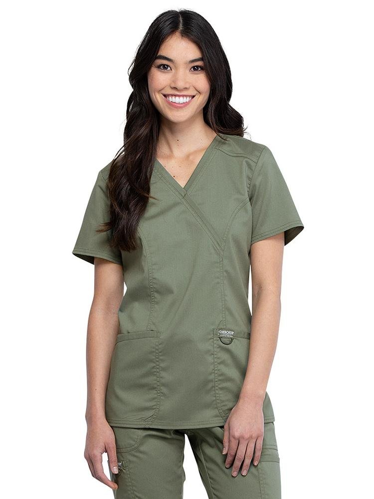 Physical Therapy Assistant wearing Cherokee Workwear Revolution women's Mock Wrap Scrub Top in olive size extra small