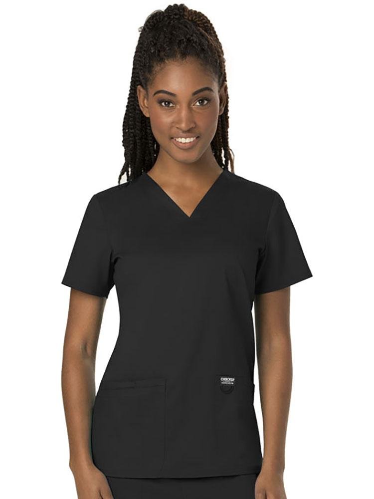 A young female Dental Hygienist wearing a Cherokee Women's Revolution Women's V-neck Scrub Top in Black size XS featuring 2 front pockets for you on the job storage needs.