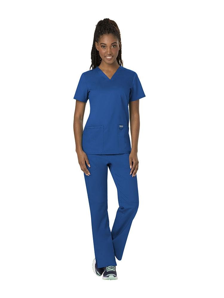 A young female Pharmacy Technician wearing both the Cherokee Workwear Revolution women's V-Neck Scrub Top & Elastic Waistband Pull-On Scrub Pant in Royal Blue size XL.