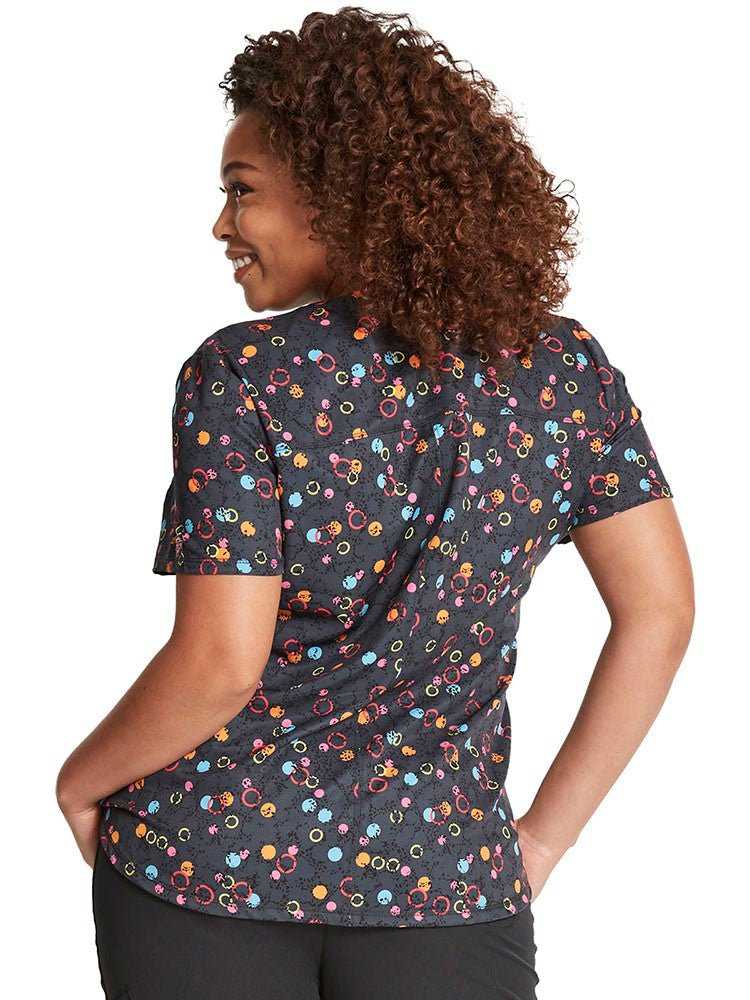 Young female healthcare professional wearing a Dickies Women's Zip-up Top in Dot's So Bright featuring a full zip front with ring-shaped zipper pull, a rib-knit neckband & curved front & back yoke seams.