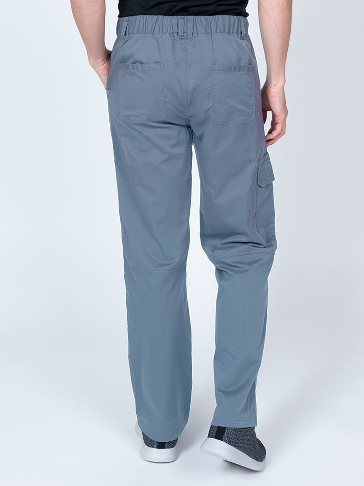 Male nurse wearing an Epic by MedWorks Men's Button Front Scrub Pant in blue fog with 2 back pockets.