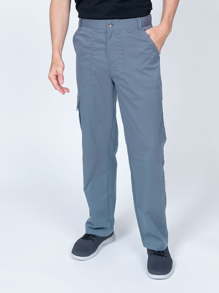 Man wearing an Epic by MedWorks Men's Button Front Scrub Pant in blue fog with metal button front closure.