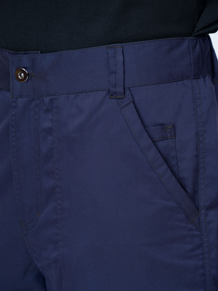 Man wearing an Epic by MedWorks Men's Button Front Scrub Pant in navy with a 6 belt loop waistline.