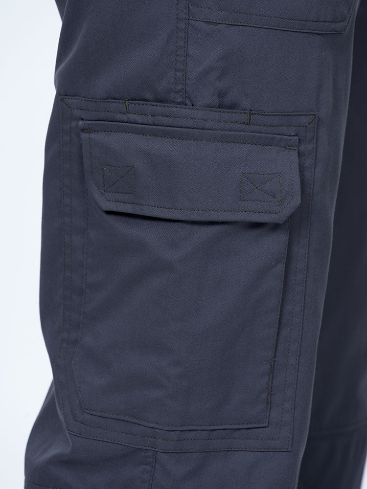 Man wearing an Epic by MedWorks Men's Button Front Scrub Pant in pewter with 1 double cargo pocket on wearer's right side.