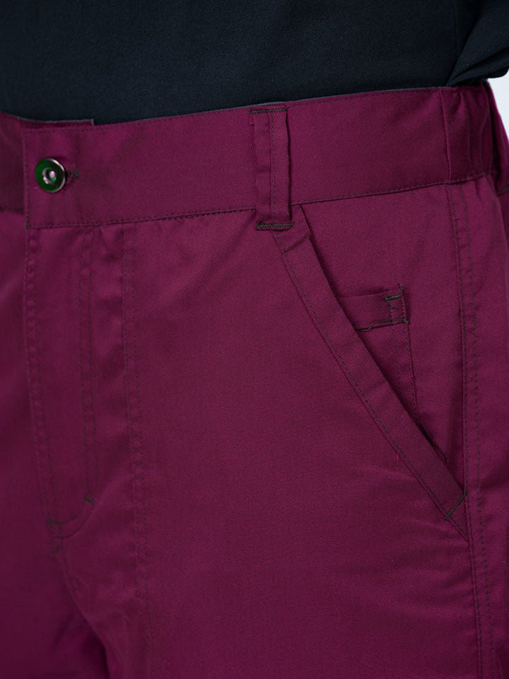 Man wearing an Epic by MedWorks Men's Button Front Scrub Pant in wine with a 6 belt loop waistline.