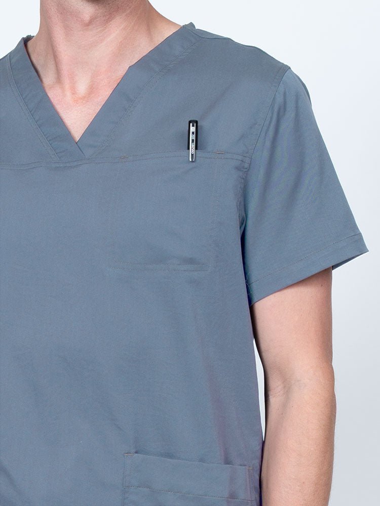 Male nurse wearing an Epic by MedWorks Men's Scrub Top in blue fog with a "hidden" front chest pocket.