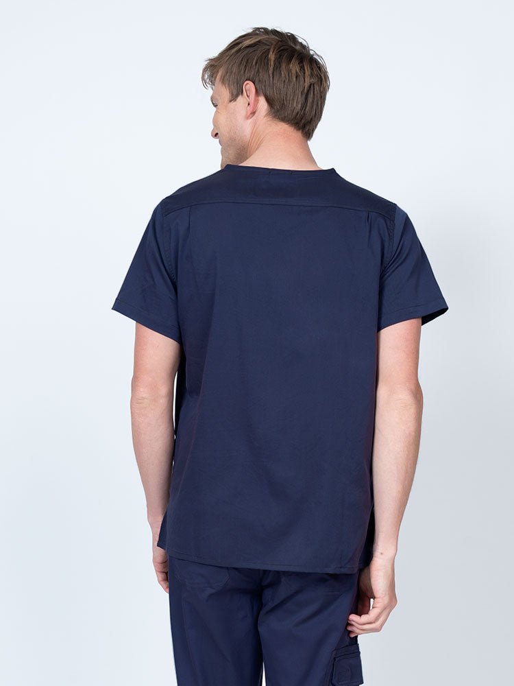 Male nurse wearing an Epic by MedWorks Men's Scrub Top in navy with a back yoke to keep a form-fitting look.