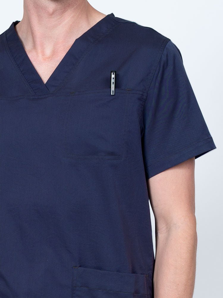 Male nurse wearing an Epic by MedWorks Men's Scrub Top in navy with a "hidden" front chest pocket.
